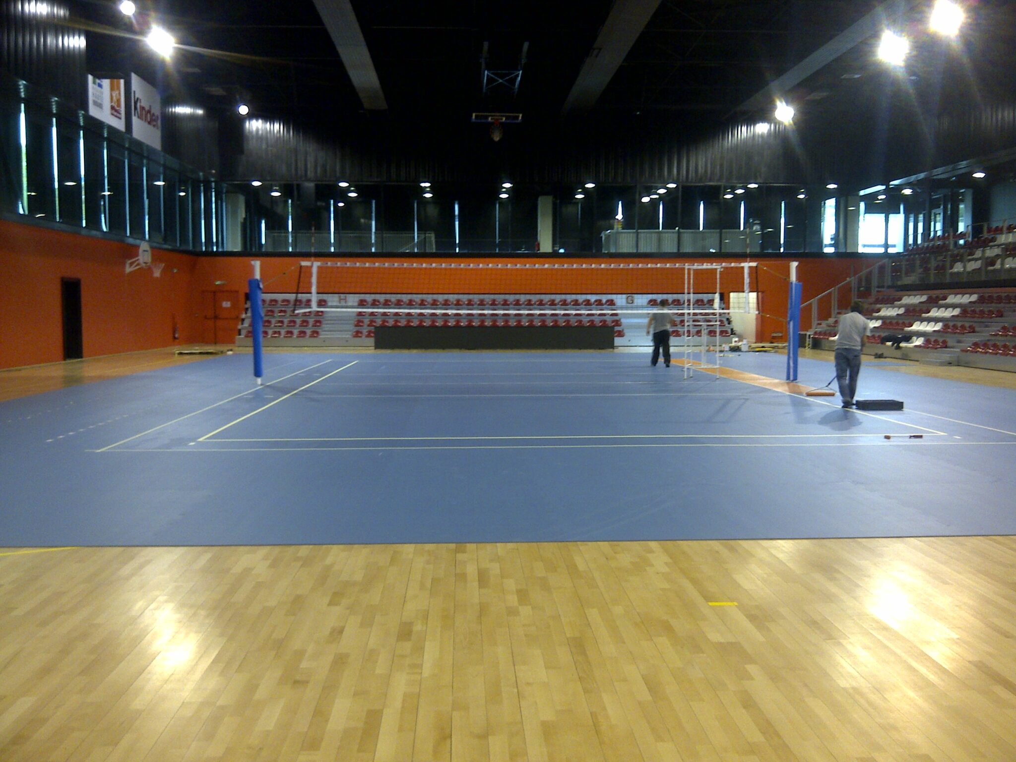 Salle de sport intérieure avec terrain de volley-ball.