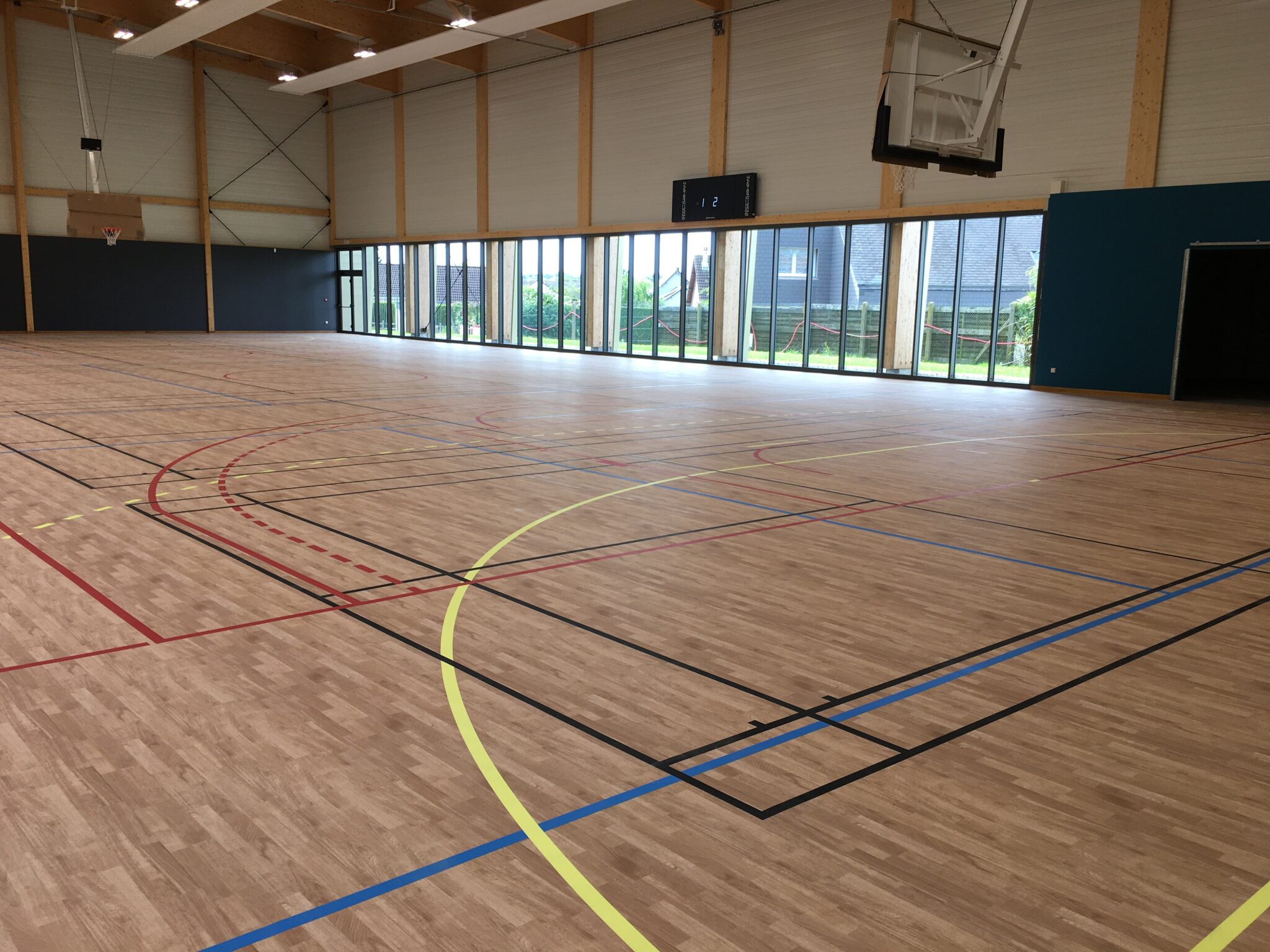 Gymnase moderne et vide avec marquage au sol multicolore.