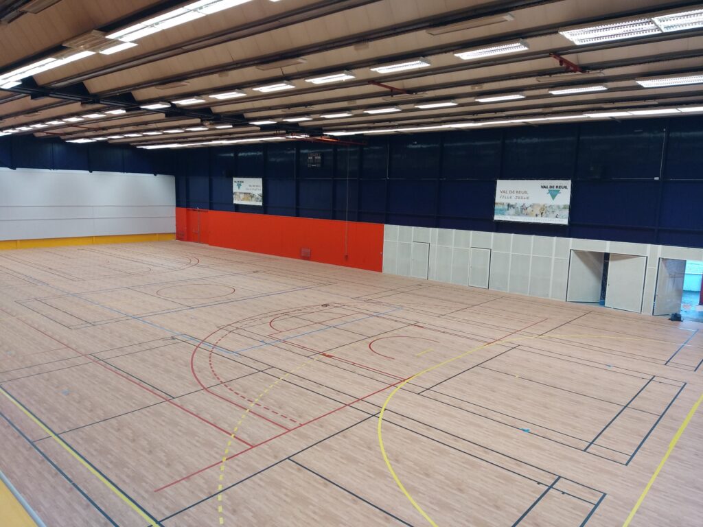Salle de sport intérieure avec terrain multisports.