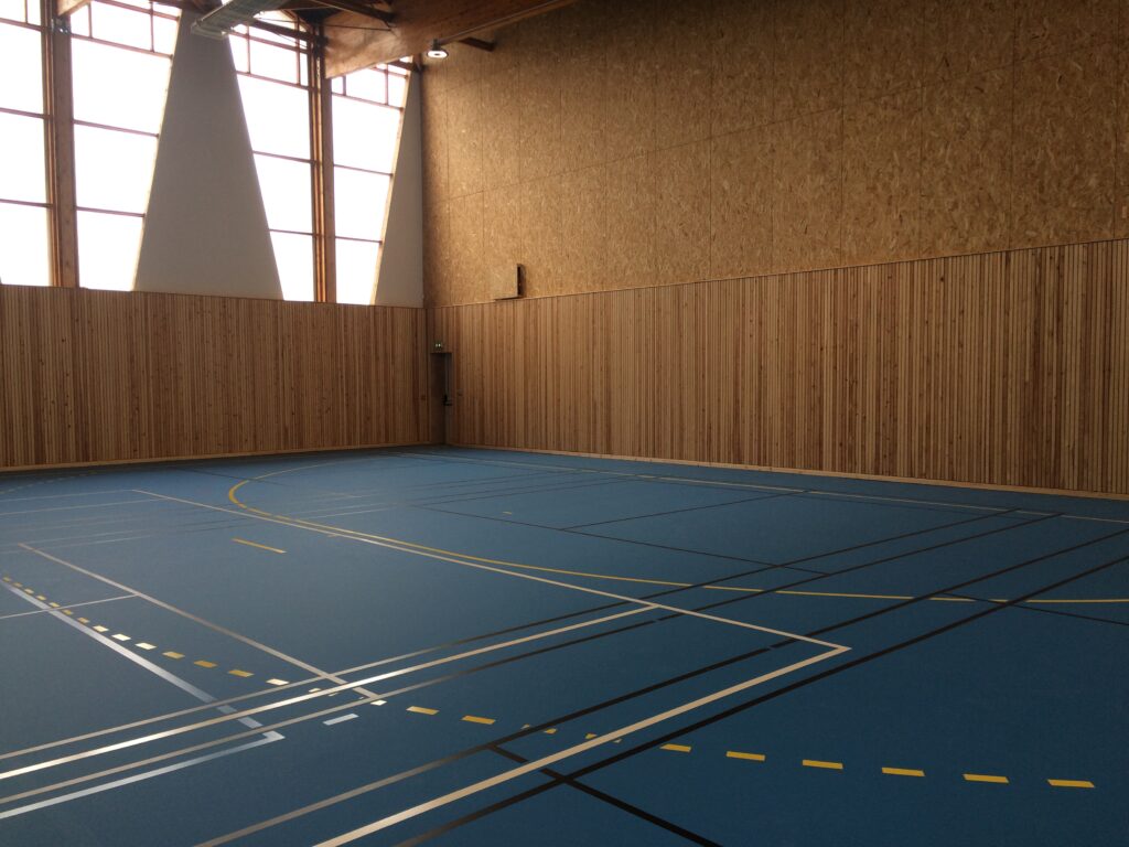 Salle de sport vide avec parquet bleu.