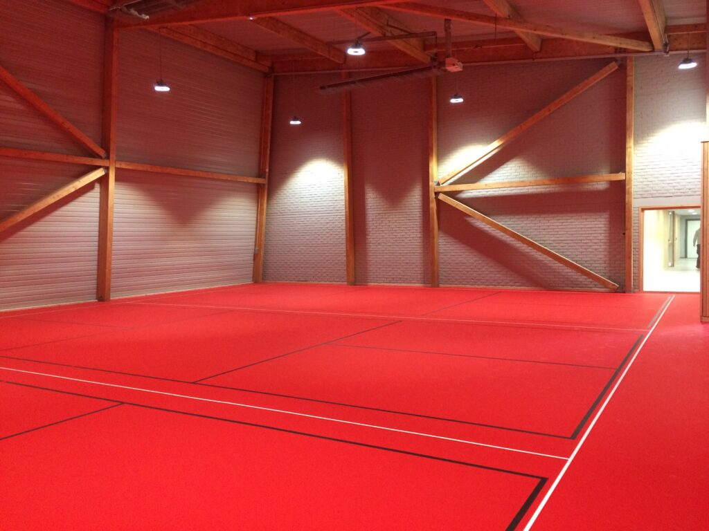 Salle de sport vide avec tapis rouge.