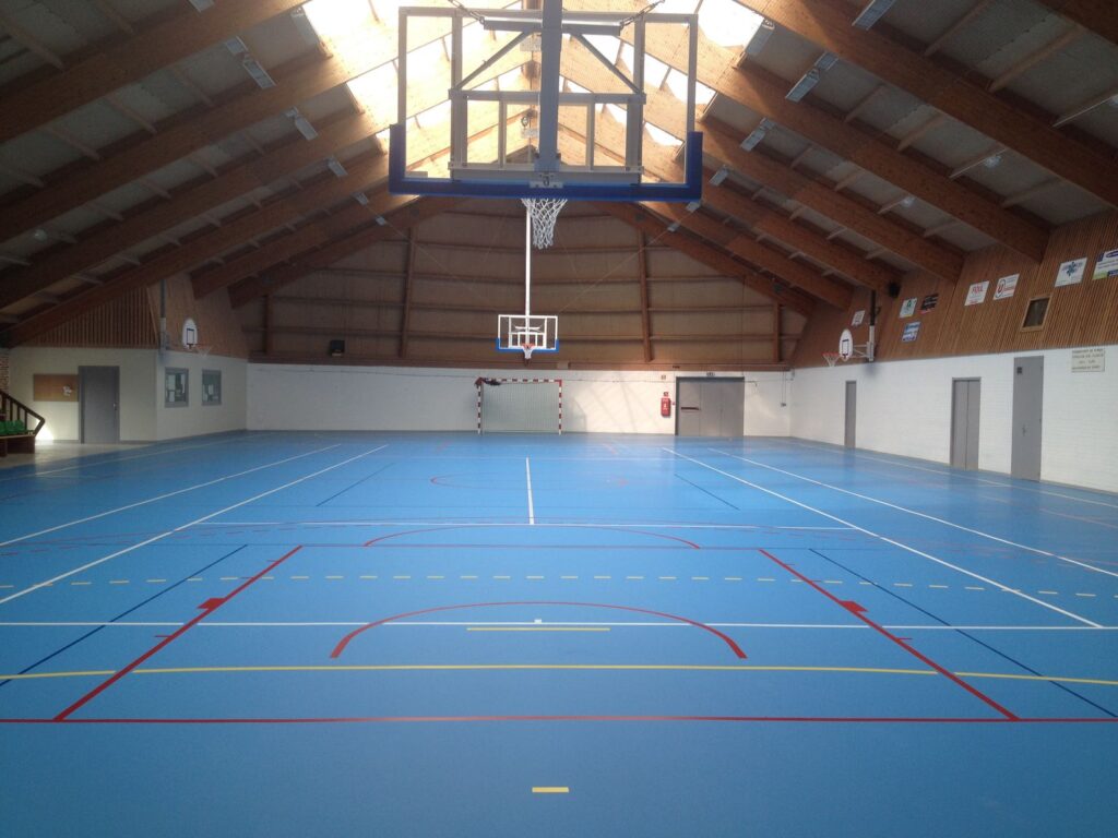Gymnase vide avec terrain de basket.