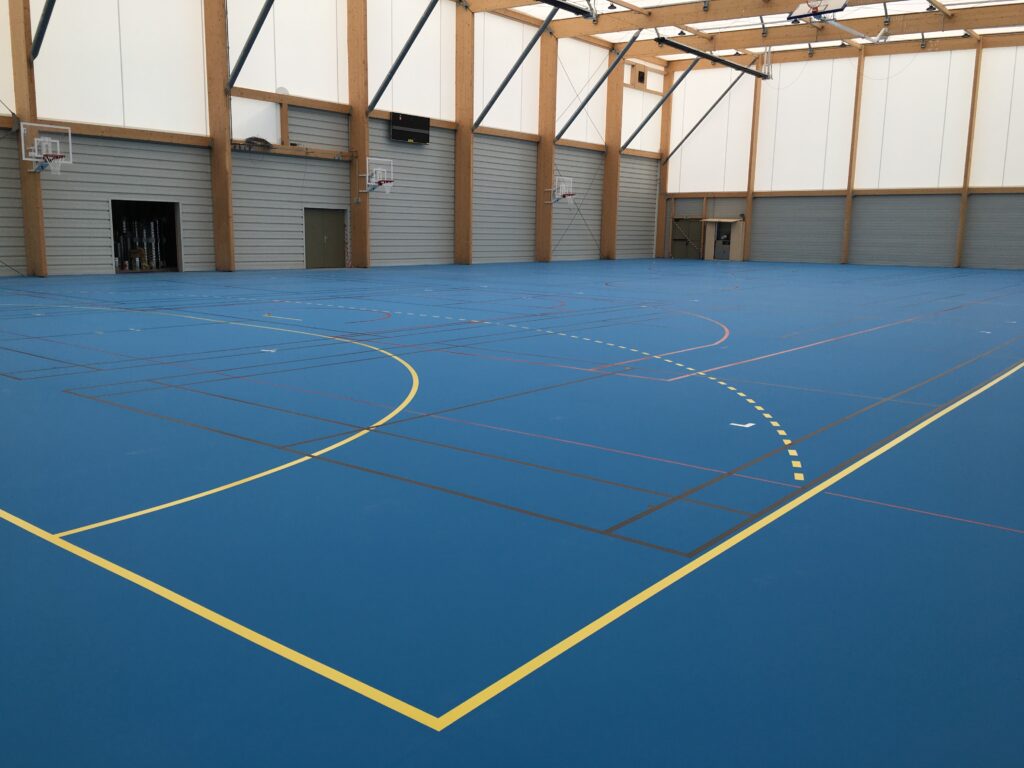 Salle de sport vide avec terrain de basket.