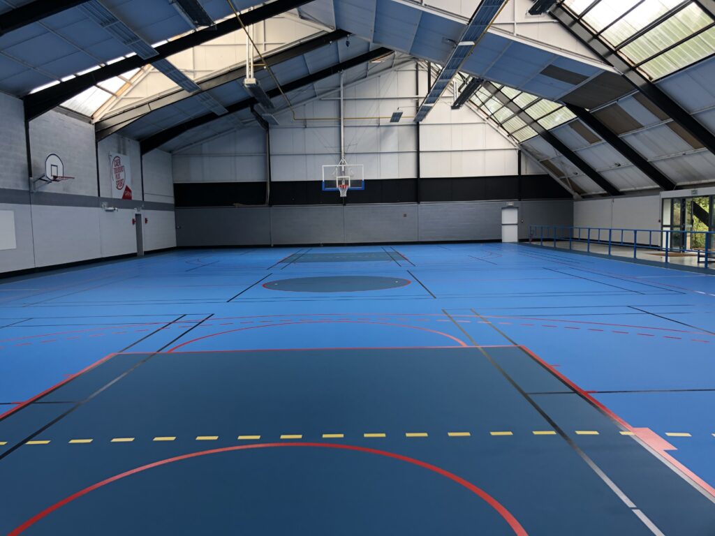 Gymnase vide avec terrain de basketball.