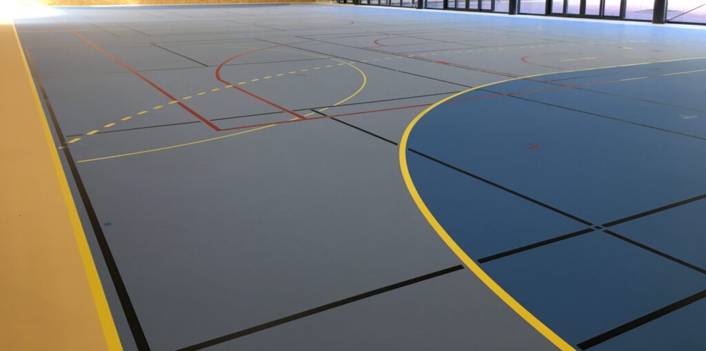 Salle multisports intérieure vide, terrain de basket.