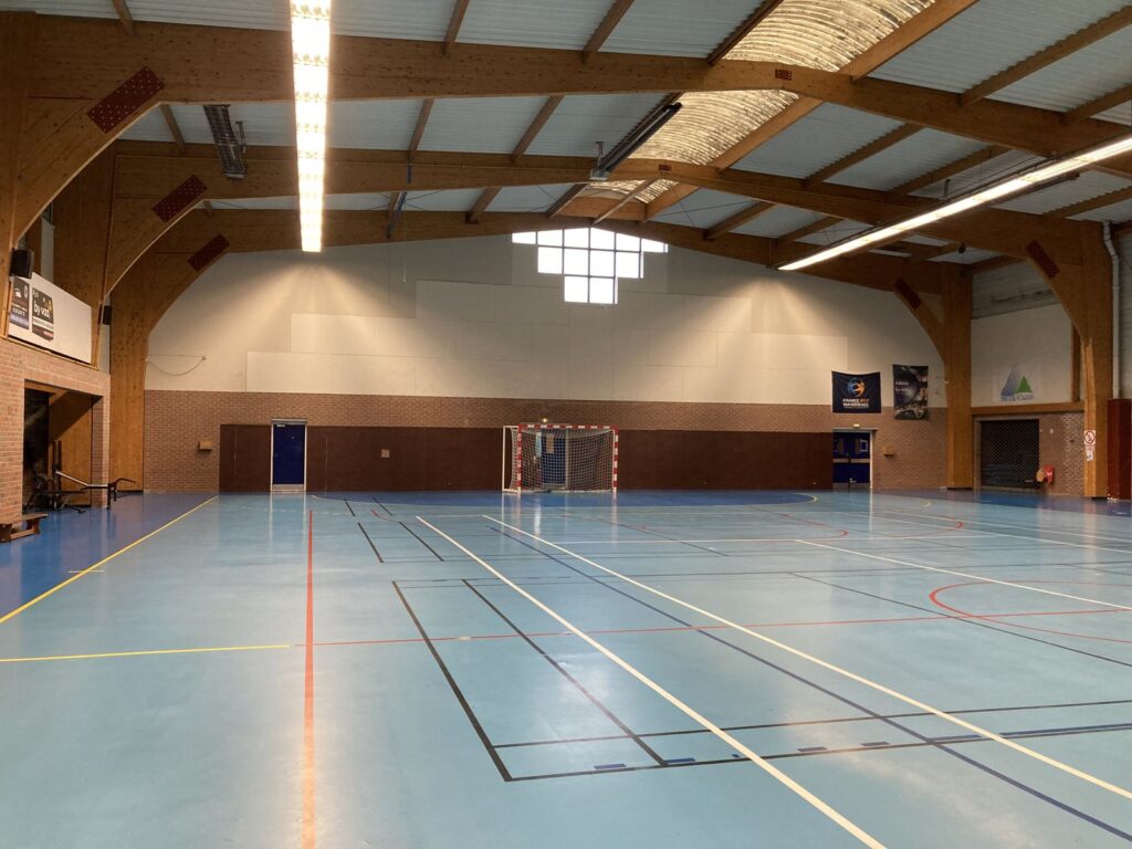 Gymnase intérieur vide avec éclairage naturel.