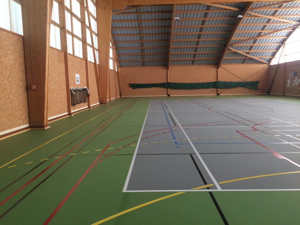 Salle de sport polyvalente vide, intérieur bois.