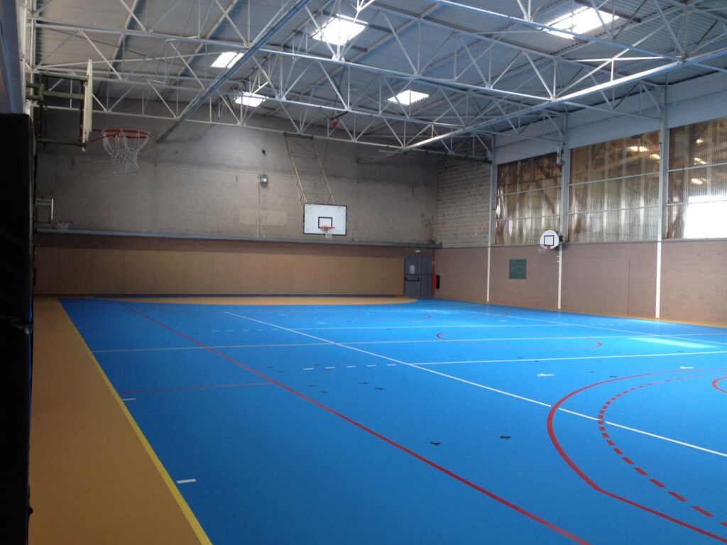 Gymnase vide avec terrain de basket.