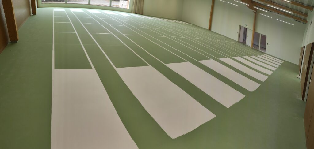 Salle de sport avec marquage au sol vert.
