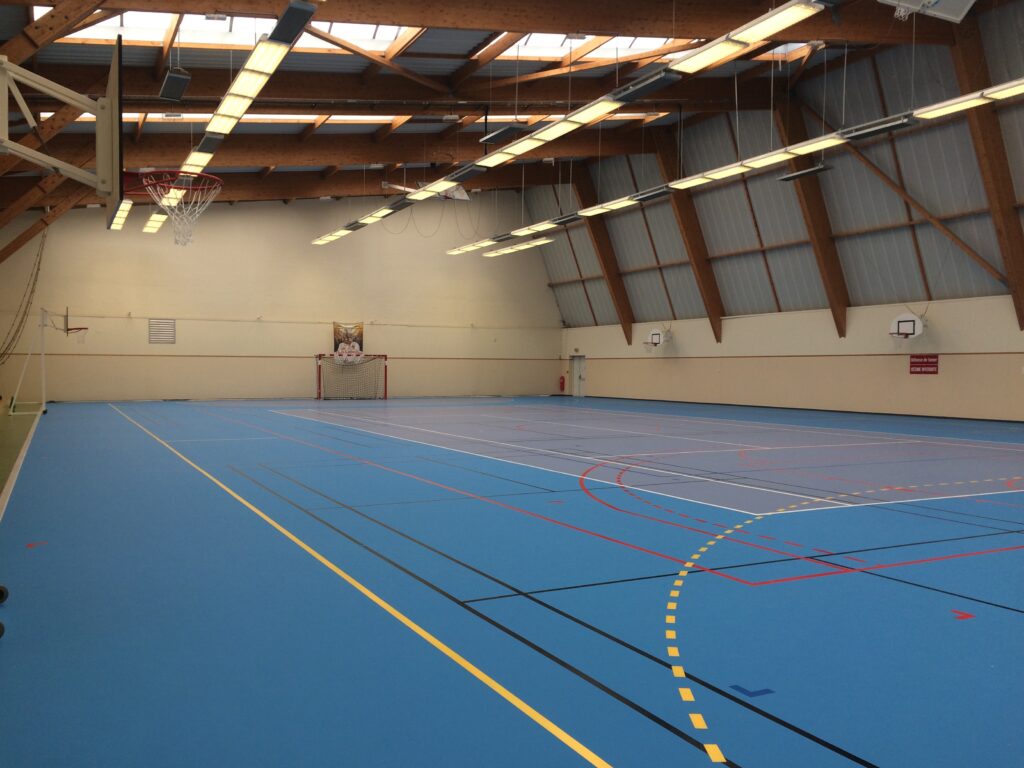 Salle de sport polyvalente vide avec terrain de basket
