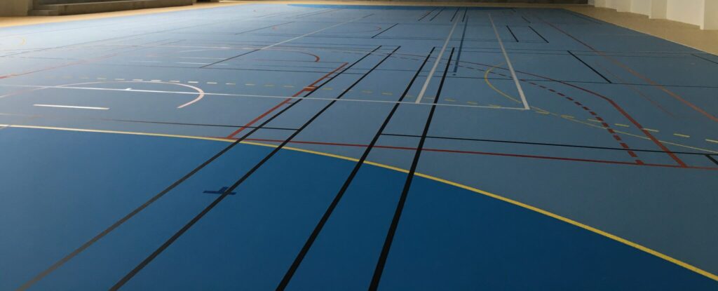 Salle de sport vide avec terrain multisports.