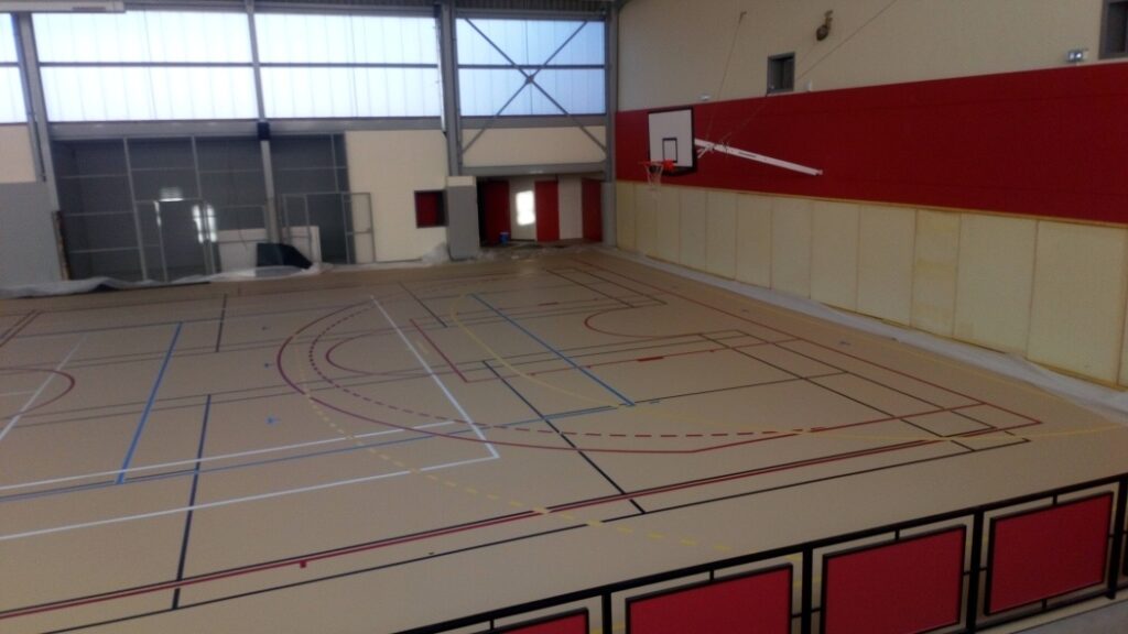 Salle de sport intérieure vide avec terrain de basket.