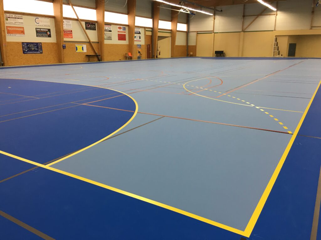 Salle de sport avec terrain multisports intérieur.