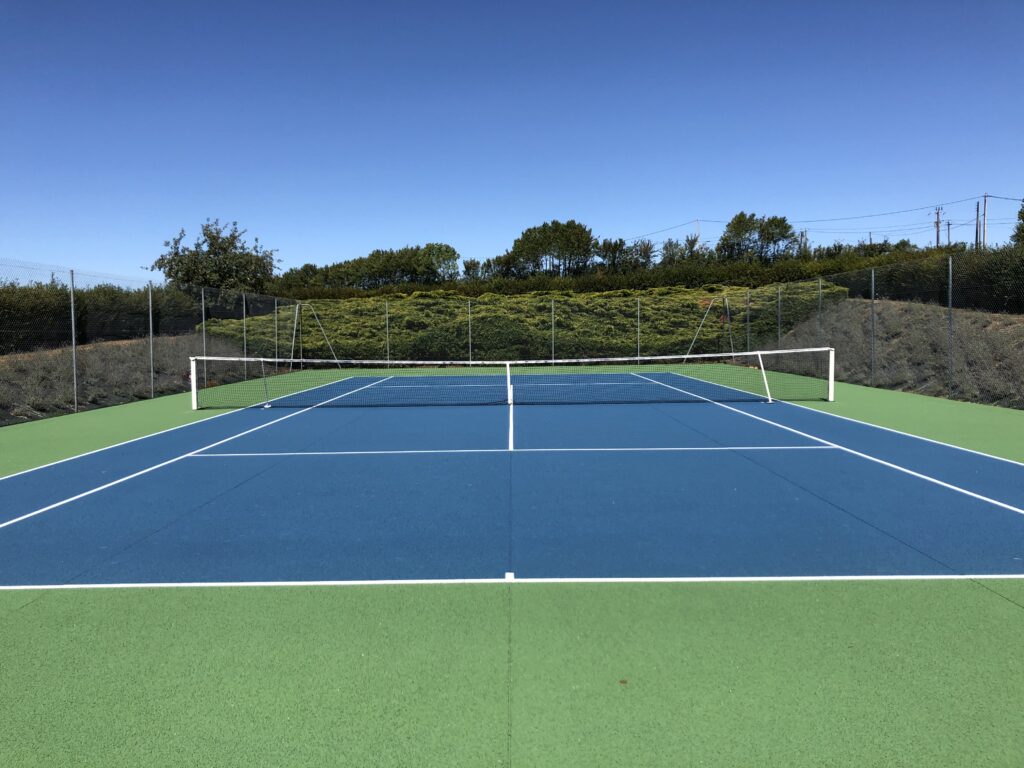 Court de tennis extérieur vide et ensoleillé.