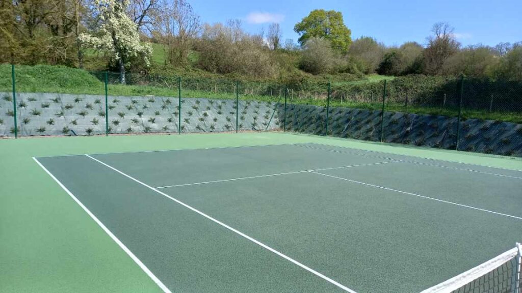 Terrain de tennis extérieur vide et verdure.