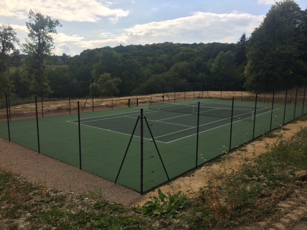 Terrain de tennis extérieur en milieu rural.