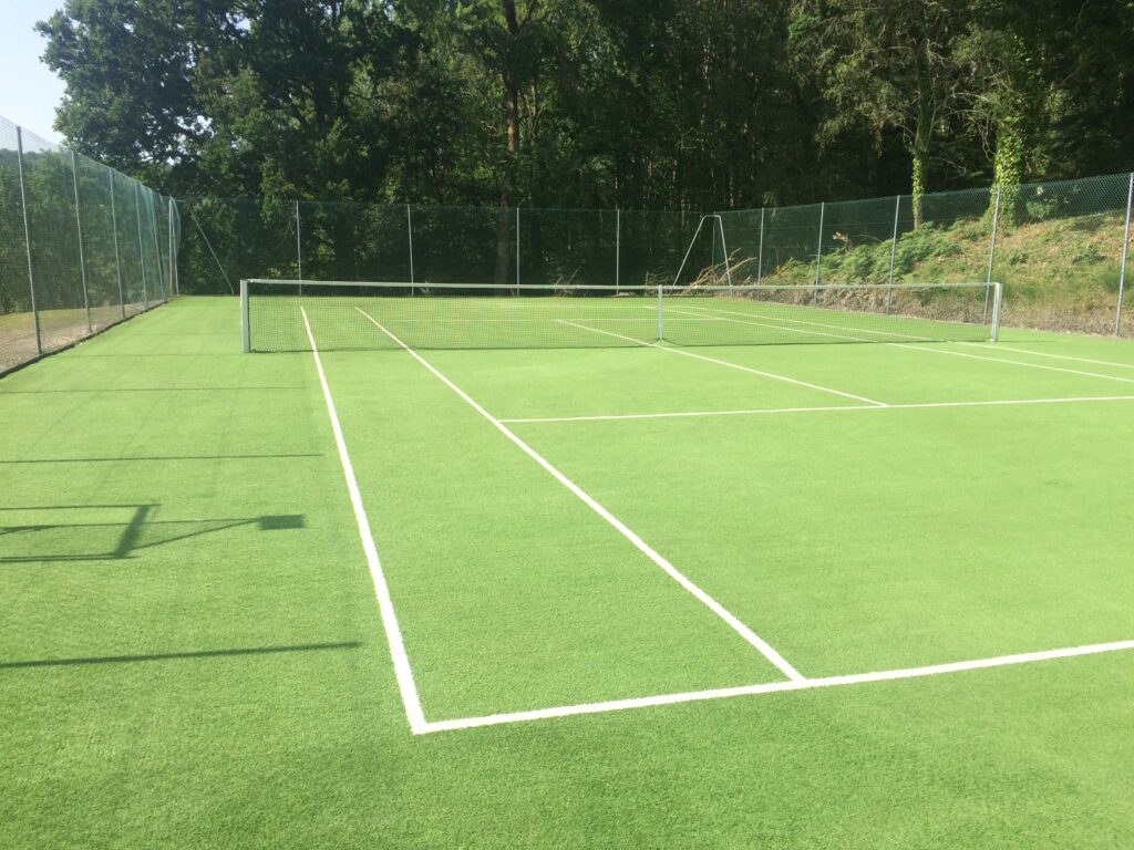 Terrain de tennis extérieur en gazon synthétique.