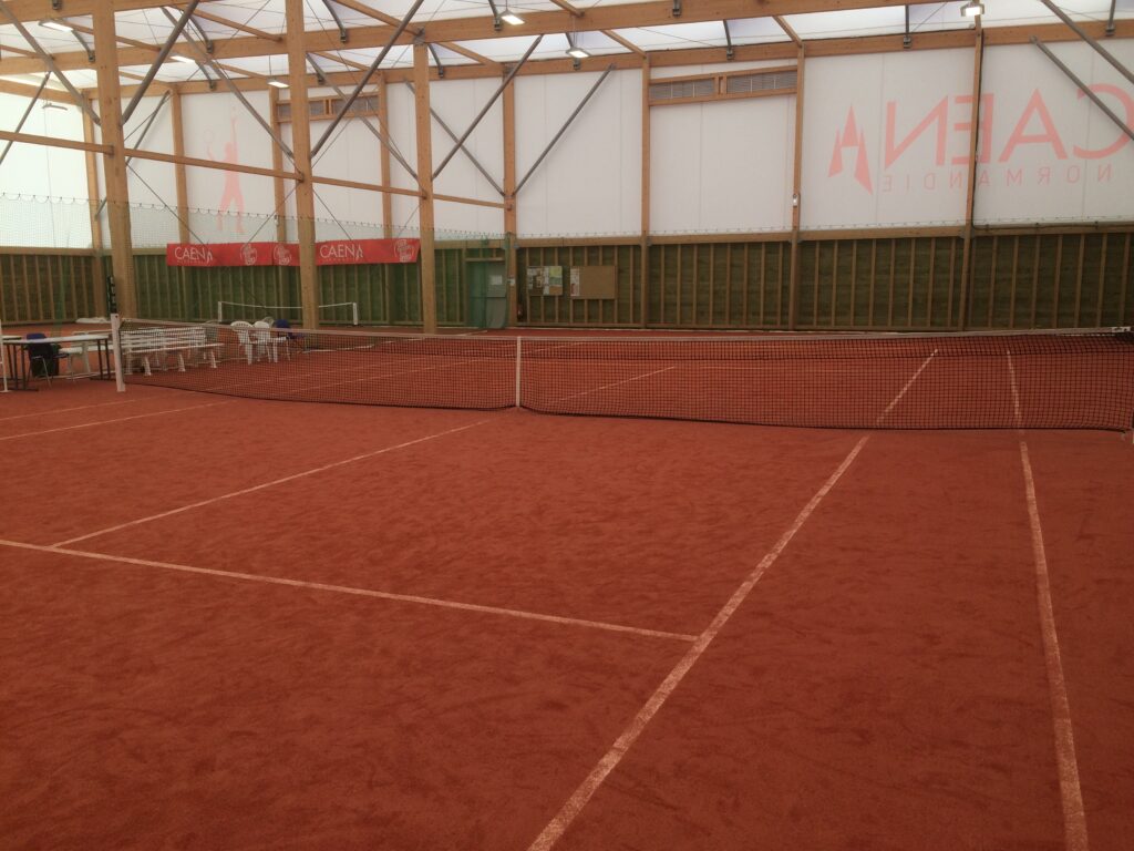 Terrain de tennis intérieur en terre battue.