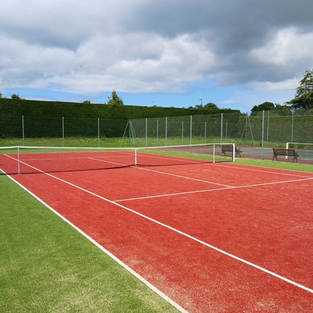 Terrain de tennis extérieur rouge et vert.
