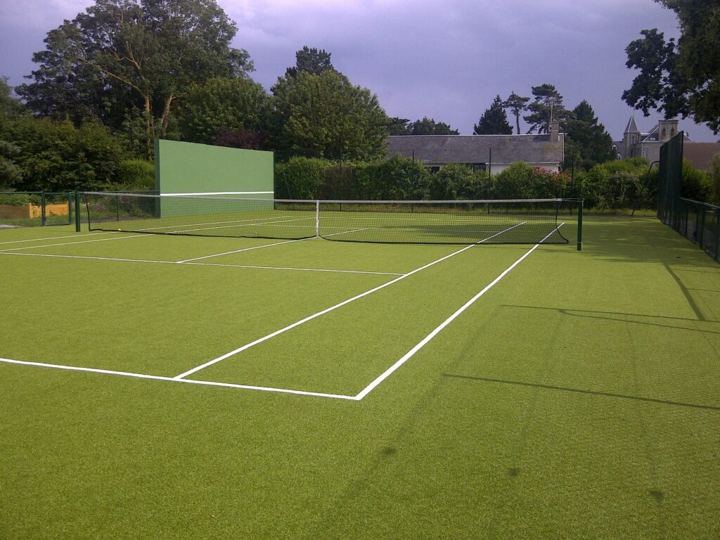 Terrain de tennis extérieur en gazon synthétique.