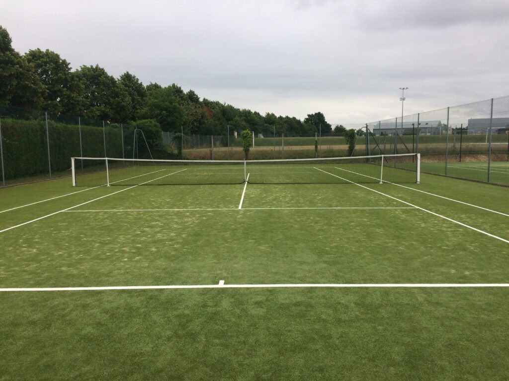 Terrain de tennis gazon synthétique vide.