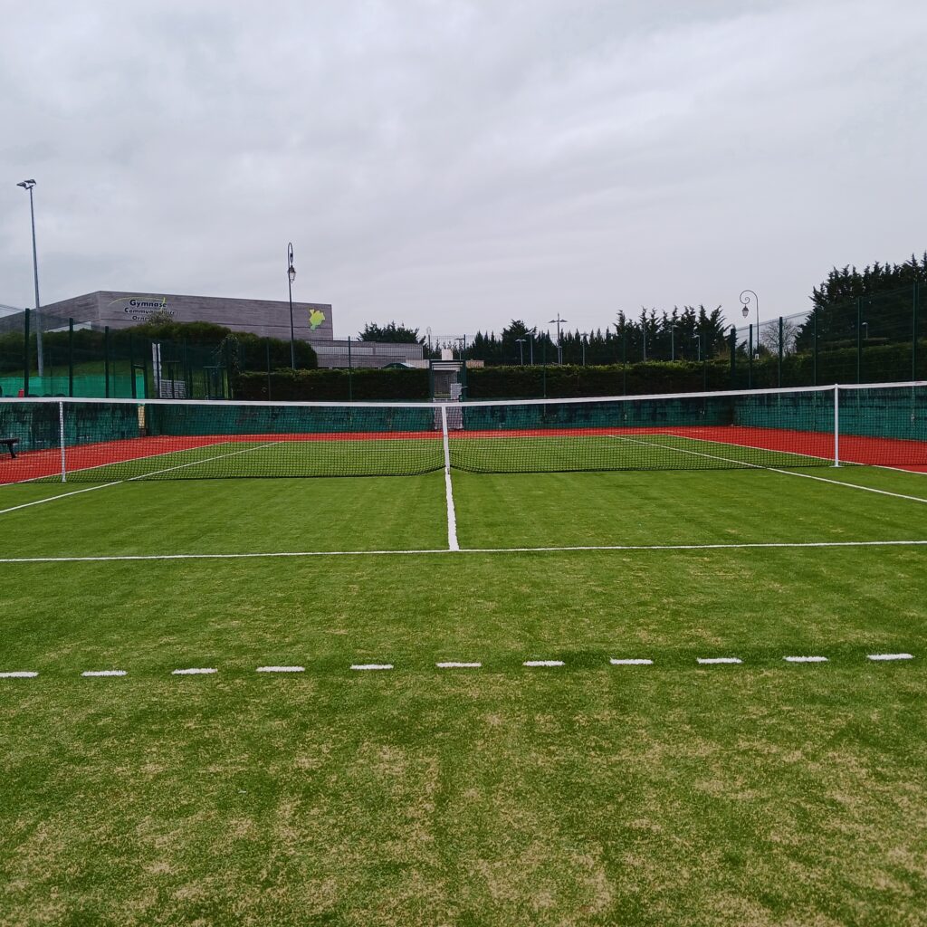 Terrain de tennis extérieur, herbe synthétique.