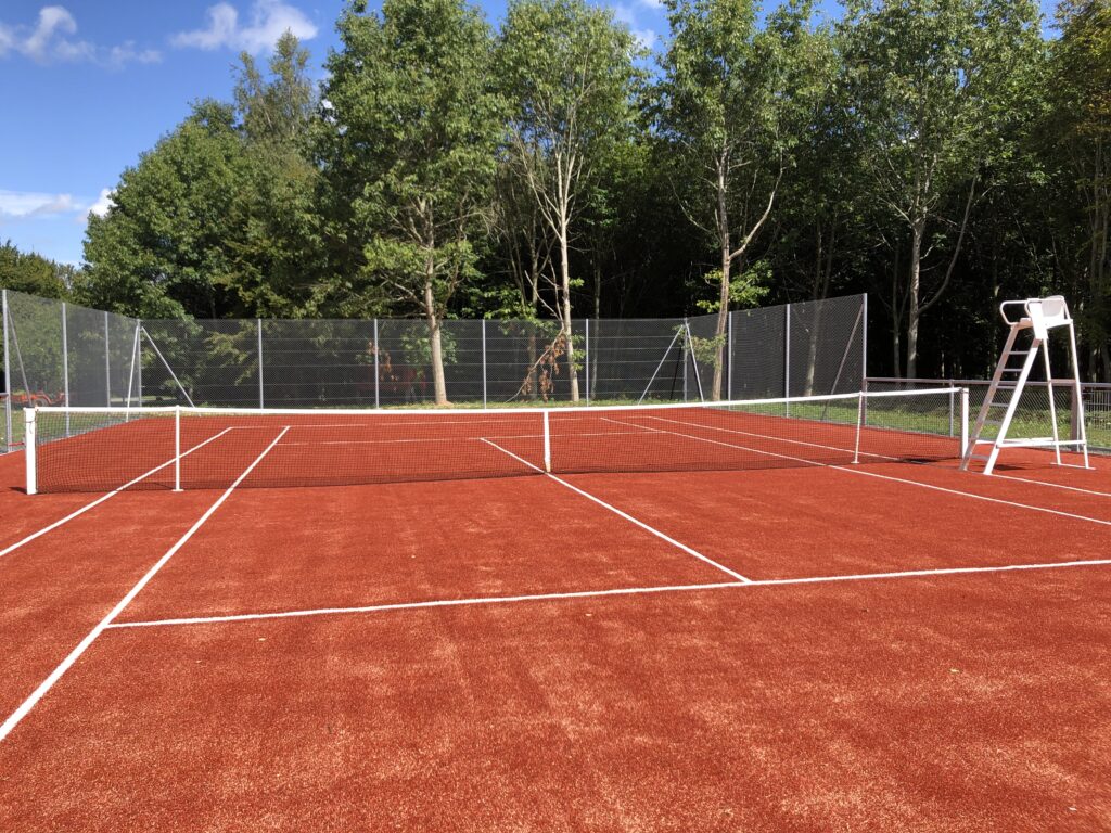 Terrain de tennis en terre battue en extérieur.