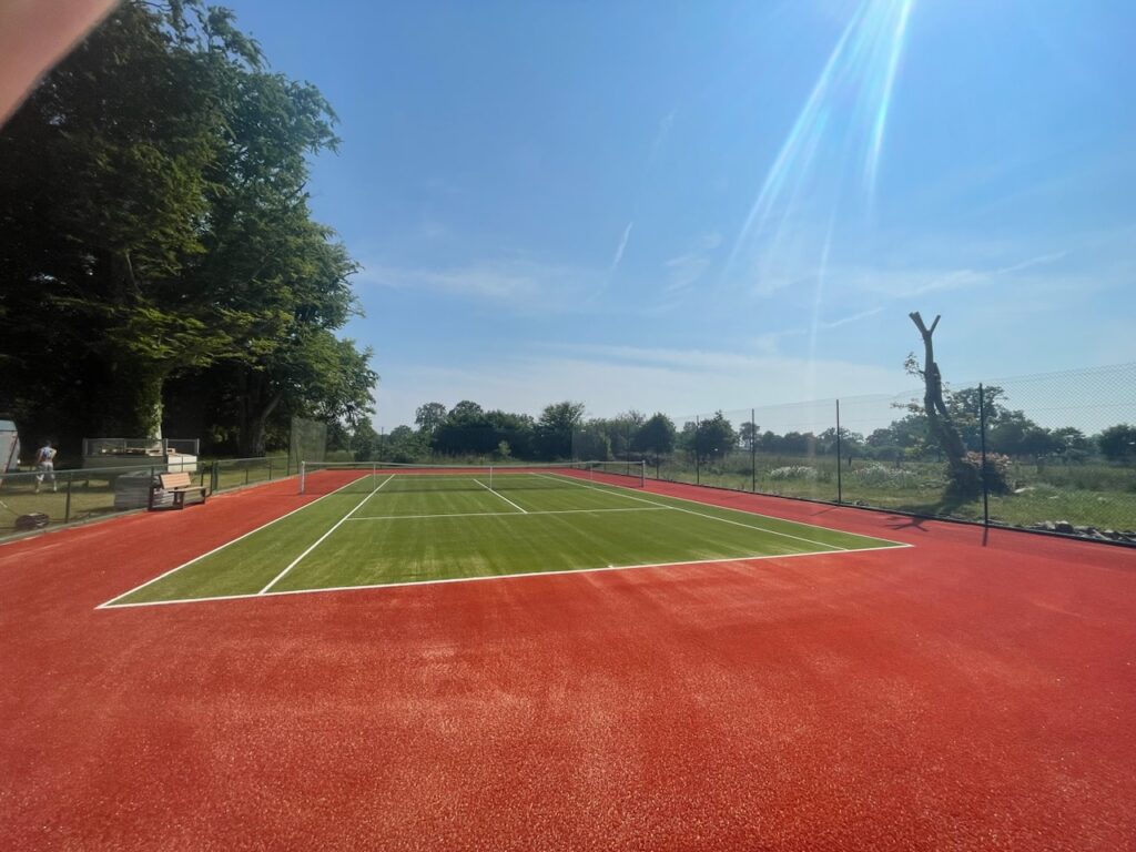 Terrain de tennis extérieur ensoleillé.