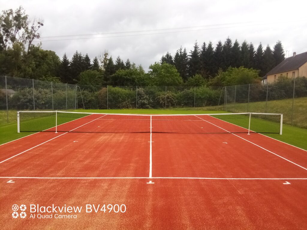 Terrain de tennis extérieur en terre battue.