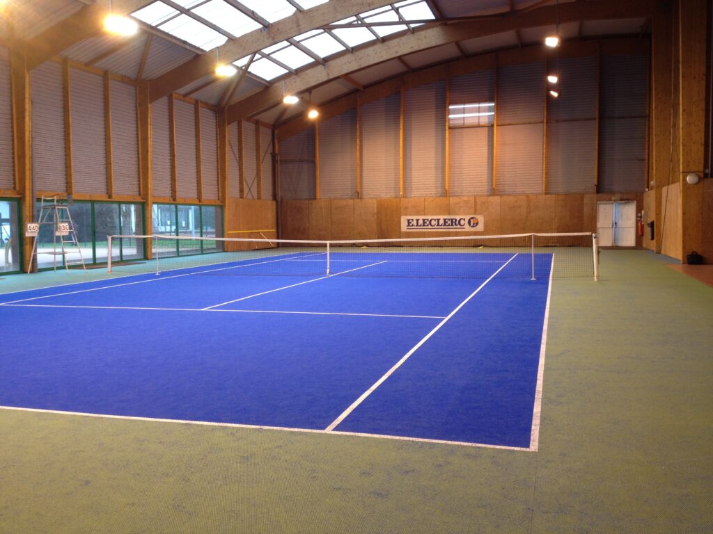 Court de tennis intérieur, surface bleue.