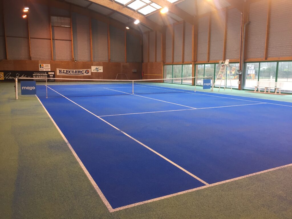 Terrain de tennis intérieur bleu et vert.