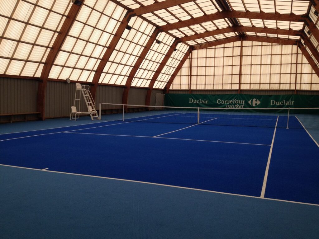 Court de tennis intérieur, toit transparent, surface bleue