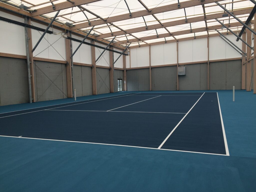 Terrain de tennis intérieur neuf et vide.