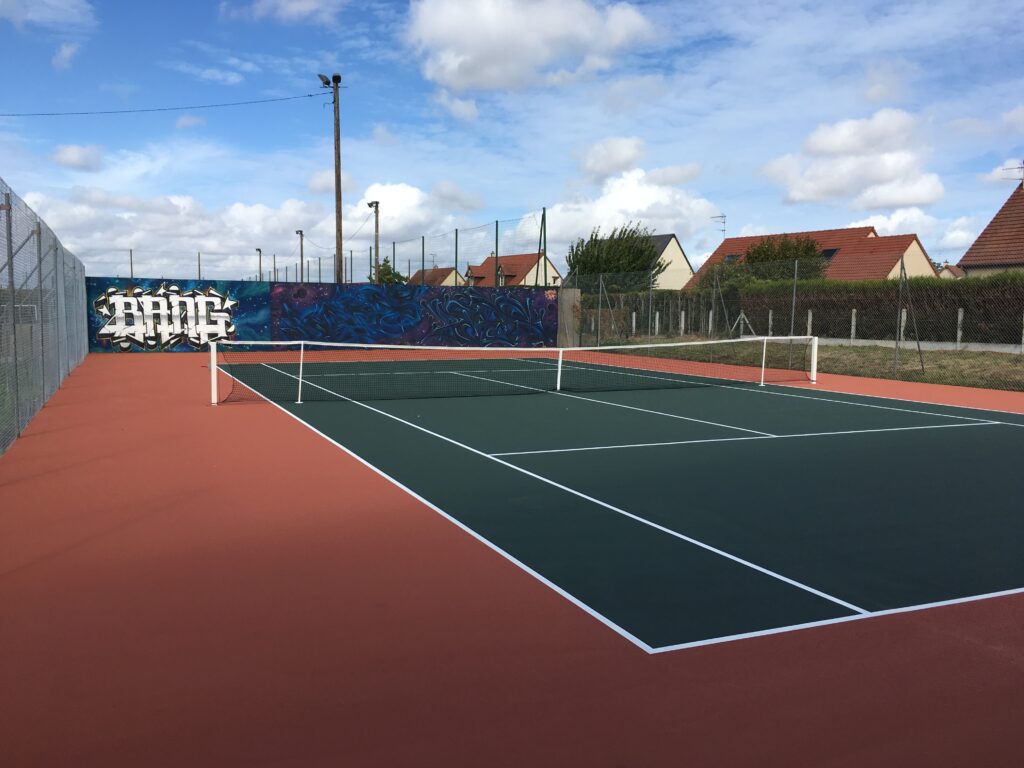 Court de tennis extérieur, mur graffité.