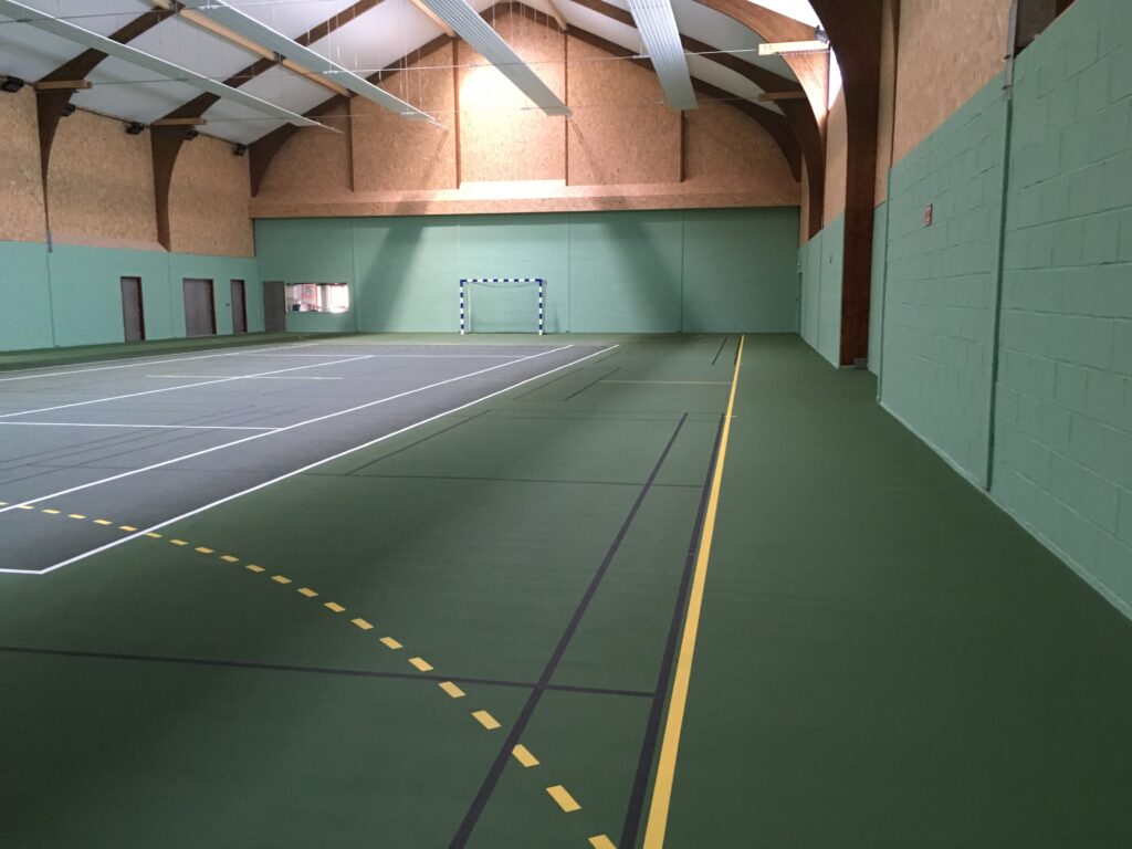 Gymnase intérieur multisport vide et éclairé.