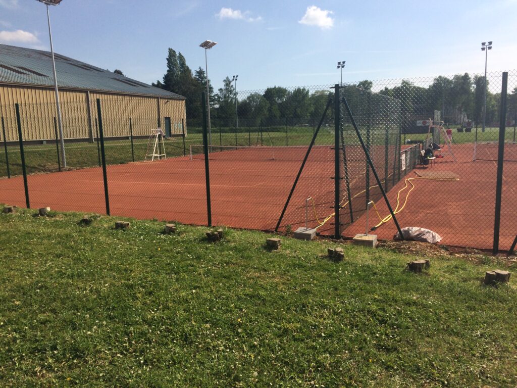 Terrain de tennis extérieur en journée.