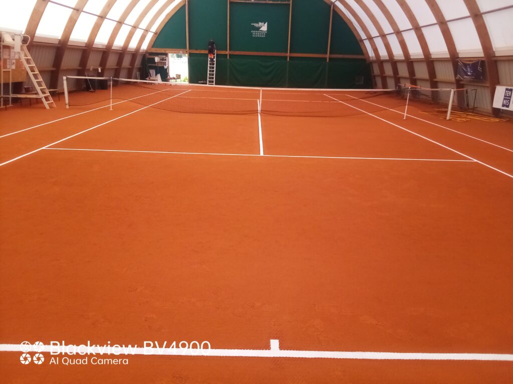 Court de tennis intérieur sur terre battue.